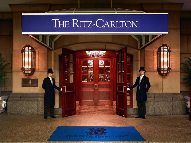 Швейцары встречают гостей у входа в казино Ritz-Carlton
