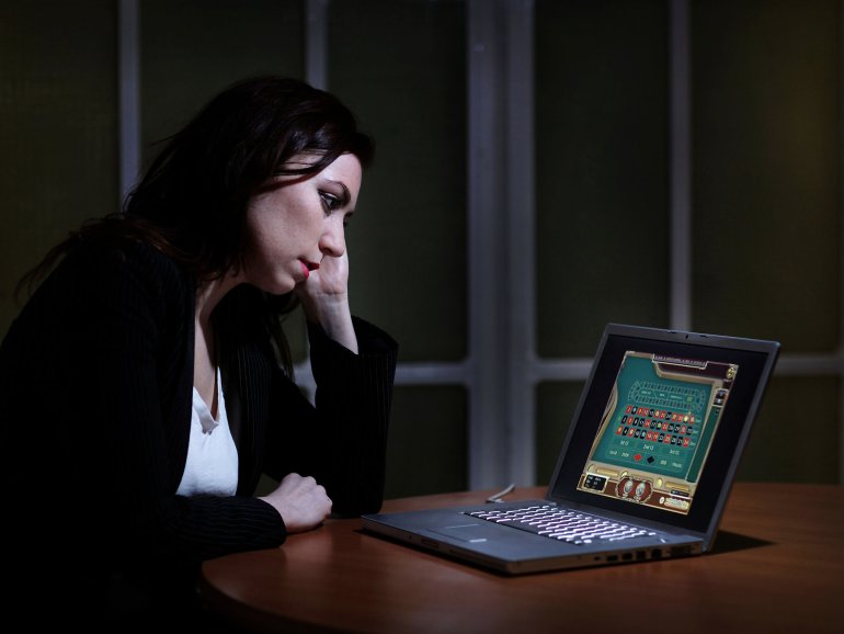 Девушка сидит за чужим ноутбуком и играет в онлайн-казино