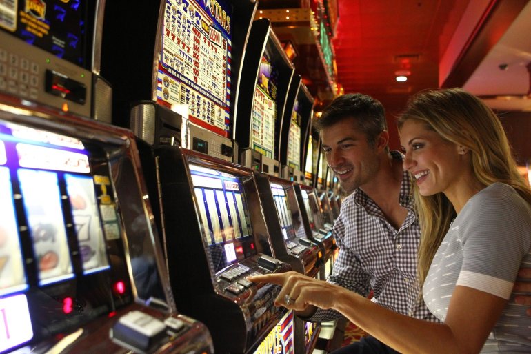 Женщина и мужчина в хорошем настроении сели играть на слотах в казино